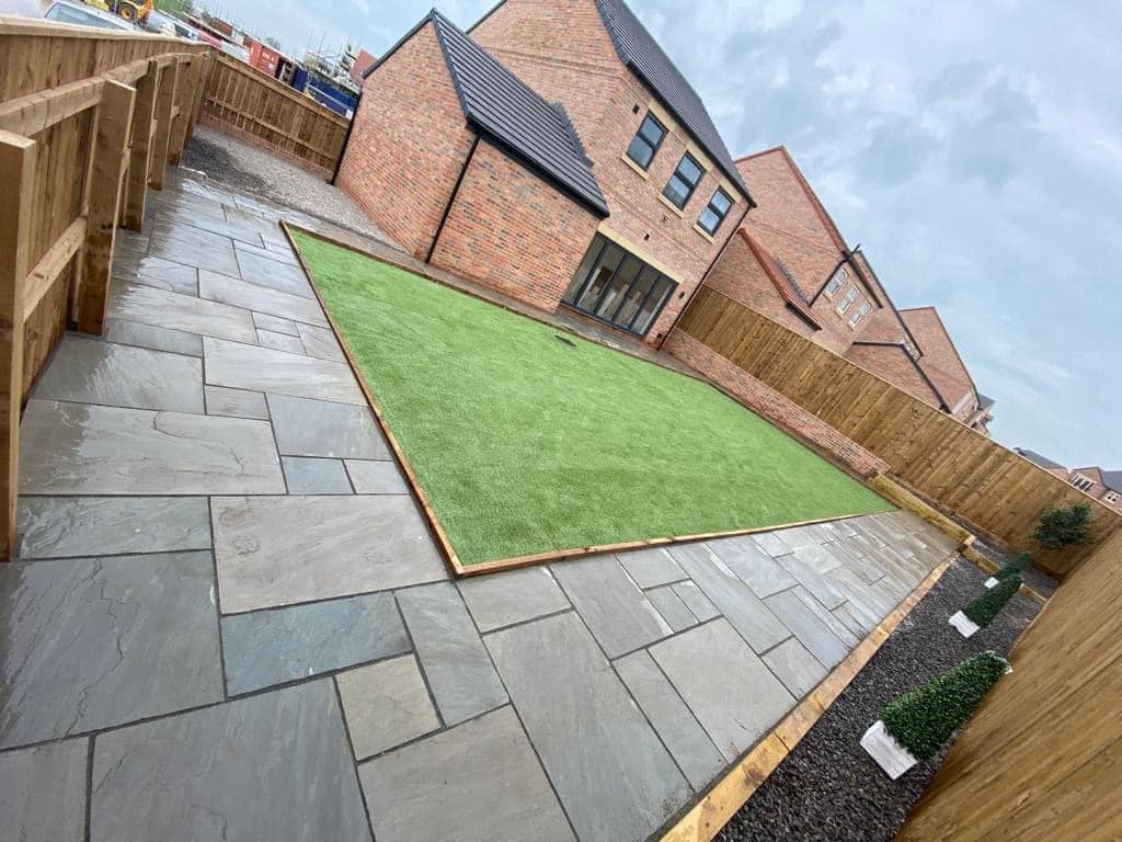 Indian sandstone patio with artificial lawn and timber fencing
