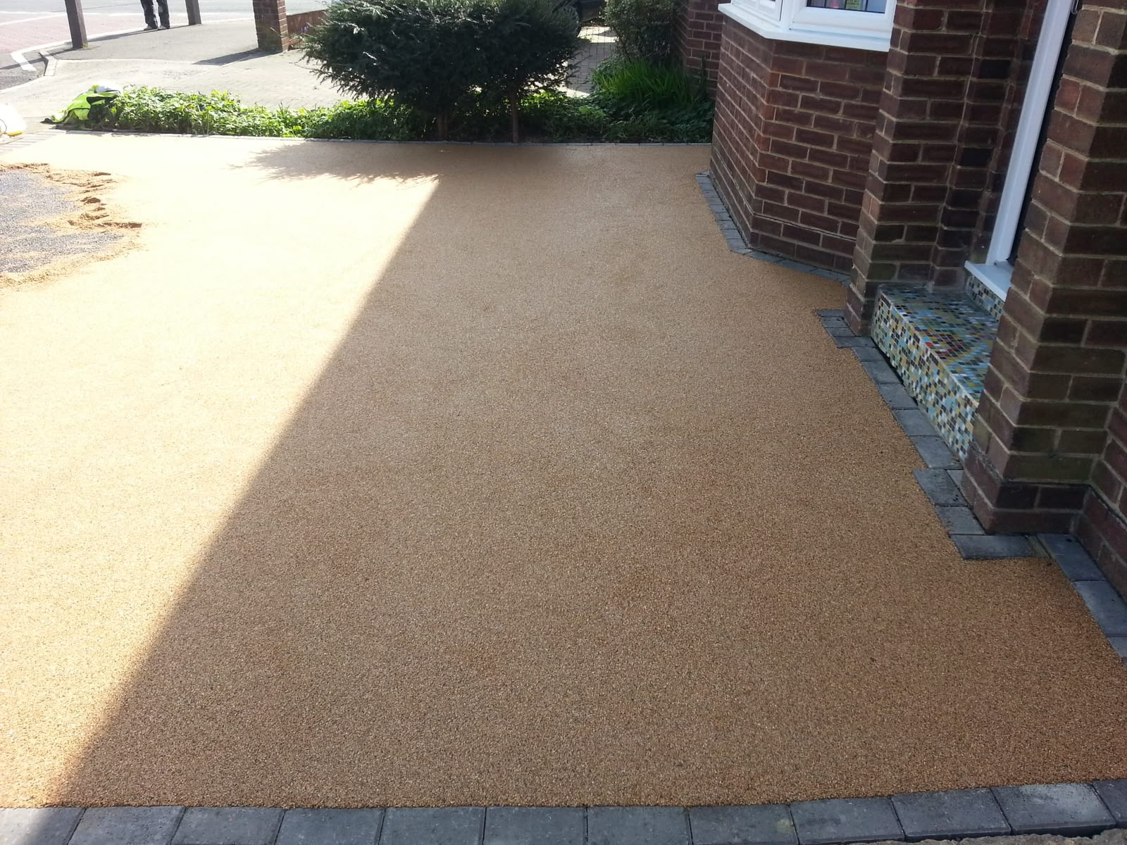 Tan resin-bound driveway with planted borders