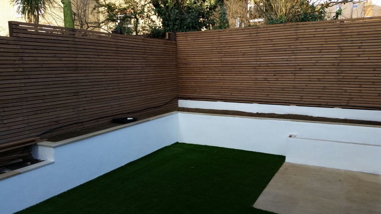 Slatted timber screening above a white rendered wall