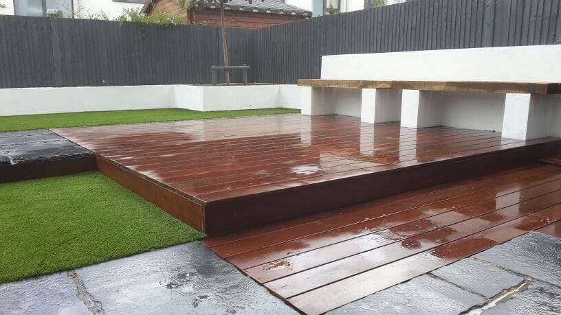 Hardwood decking, artificial lawn and rendered seating wall