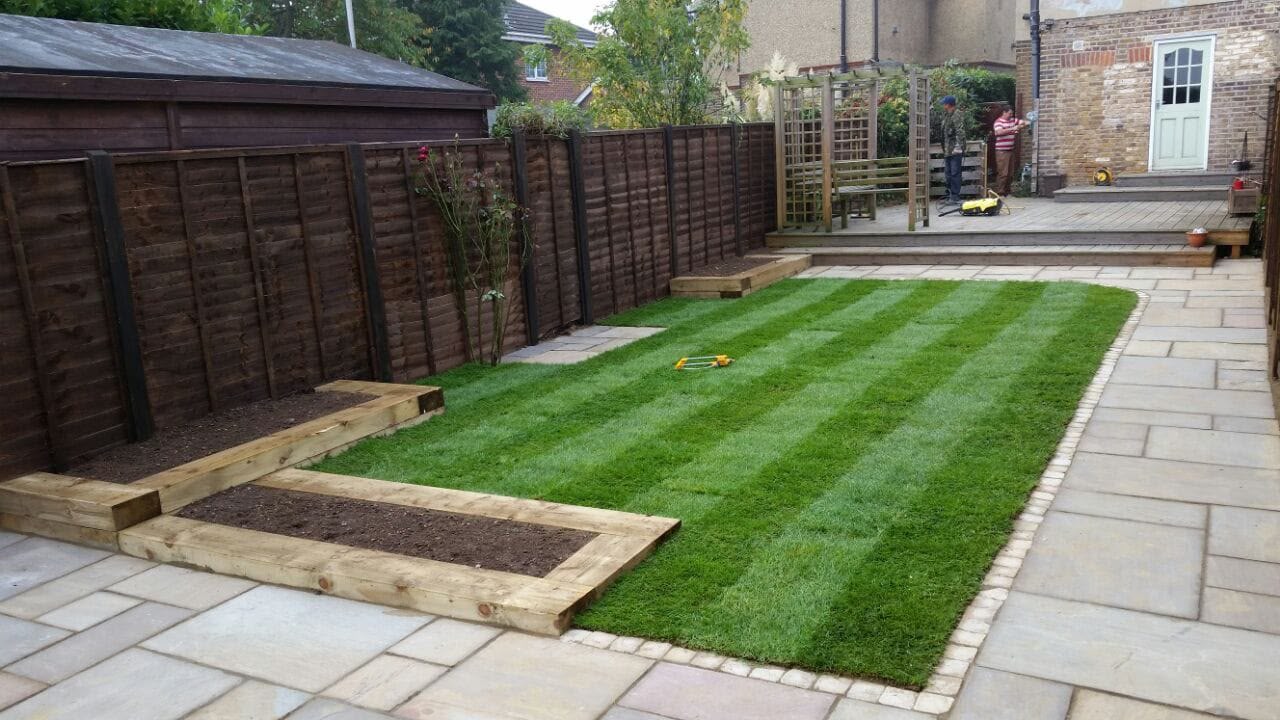 Front garden striped lawn behind a picket fence