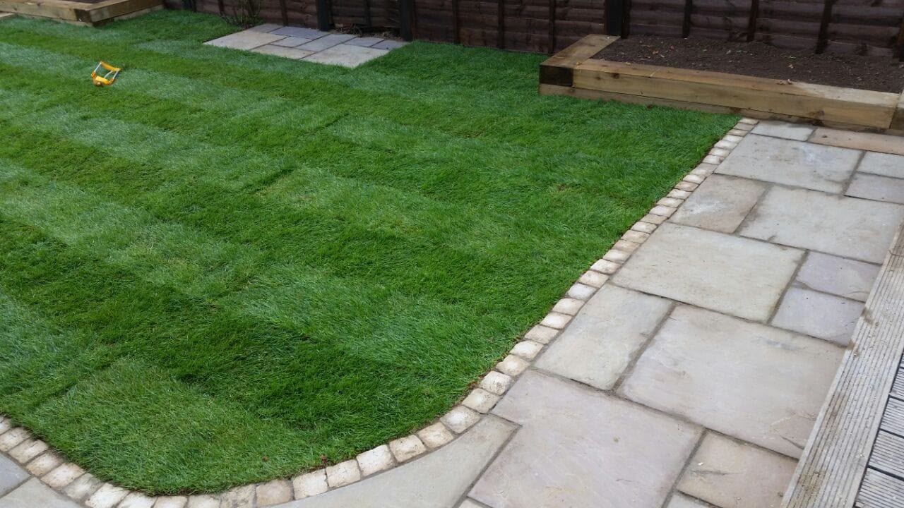 Freshly laid striped lawn with sandstone border